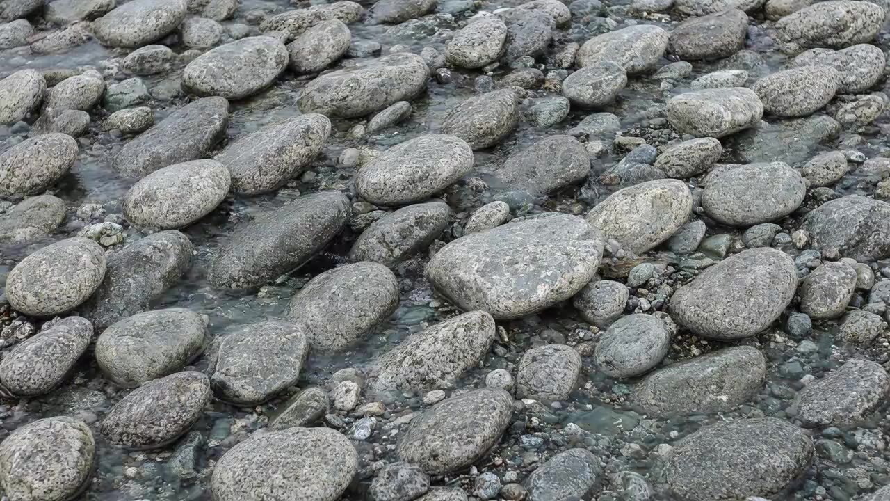 A generated picture of pale greywacke river stones under a thin sheet of clear water.