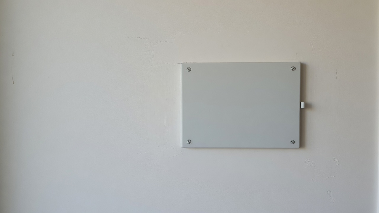 A generated placeholder image: a modern switchboard on a plain wall with its cover closed, no wiring visible.